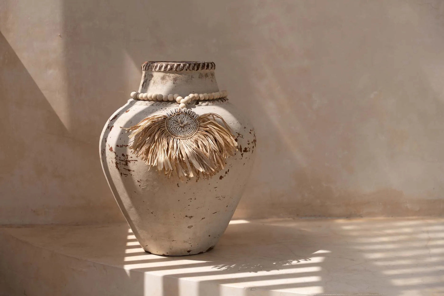 The Raffia Tajoe Tassel — Natural, cowrie shell medallion front view