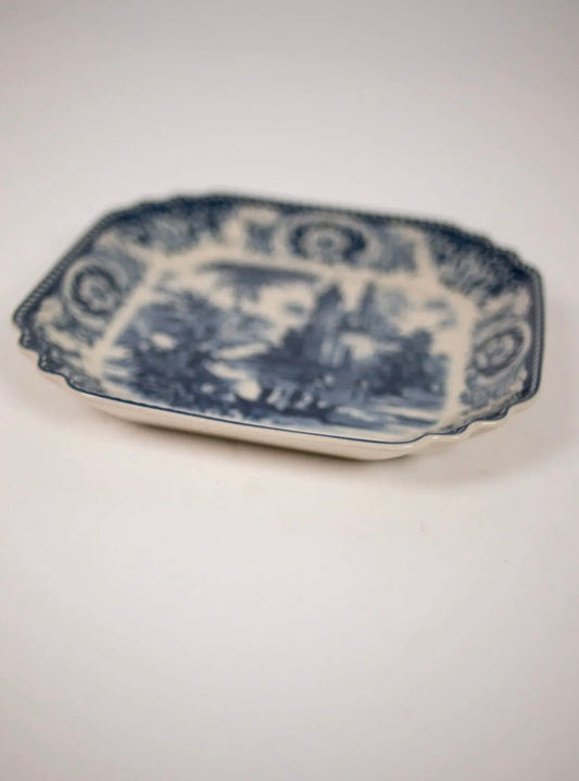 Estelle Salad Plate Blue — angled view of octagonal stoneware plate with blue toile de Jouy landscape motif on white background