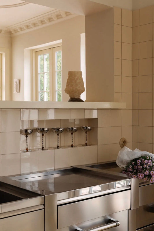 Resin Serving Bowl — four coupes lined up on kitchen counter in cream-tiled kitchen with stainless steel range