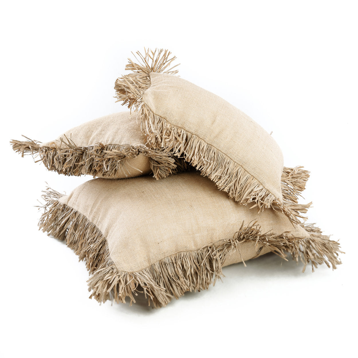 The Jute Bonita Cushion Cover in natural, styled on a white linen sofa with raffia fringe detail