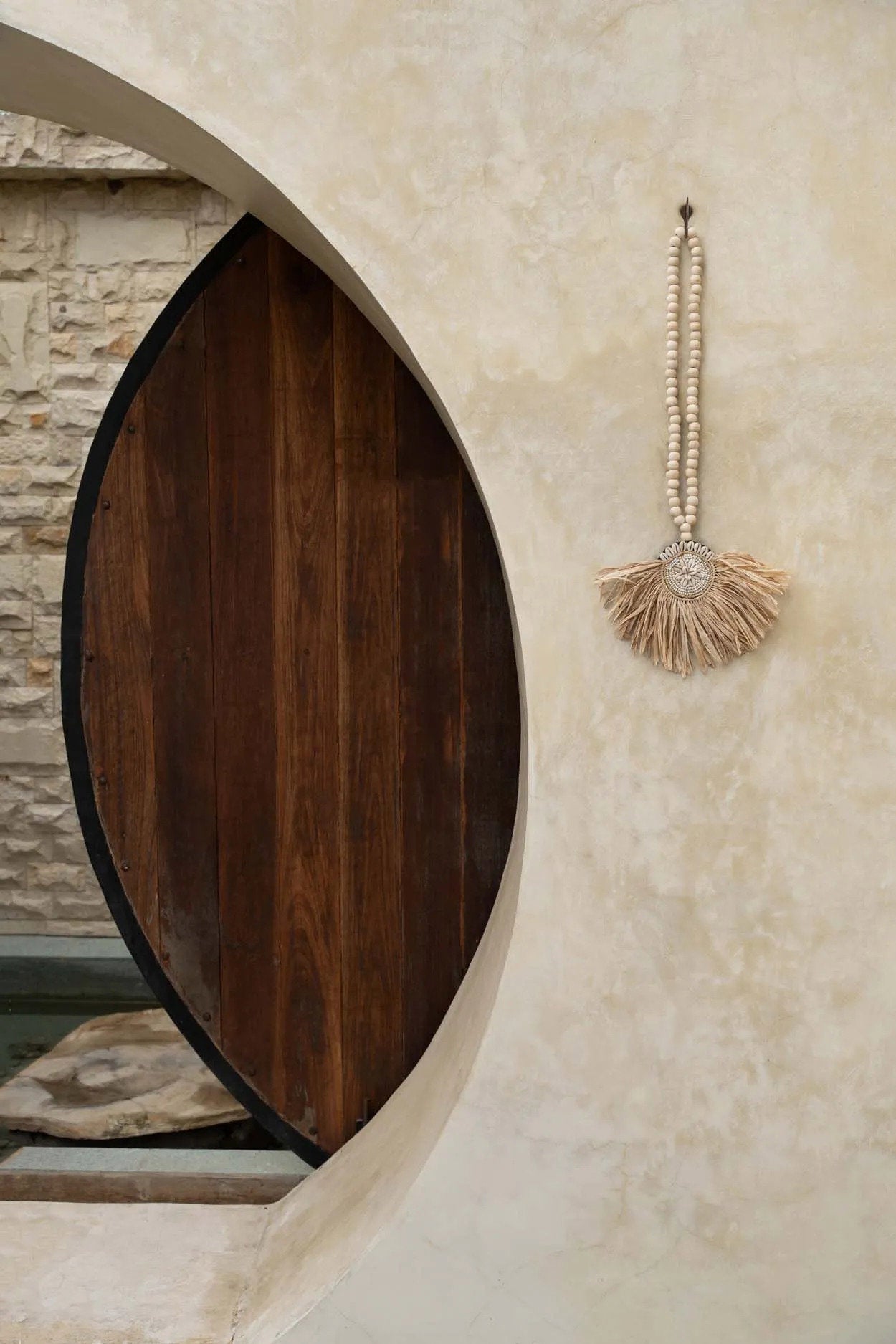 The Raffia Tajoe Tassel — Natural, black medallion variant front view