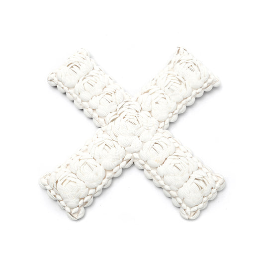 The Shell X White L — natural shell wall decor in cross form on white background, top-down view showing the overlapping shell texture