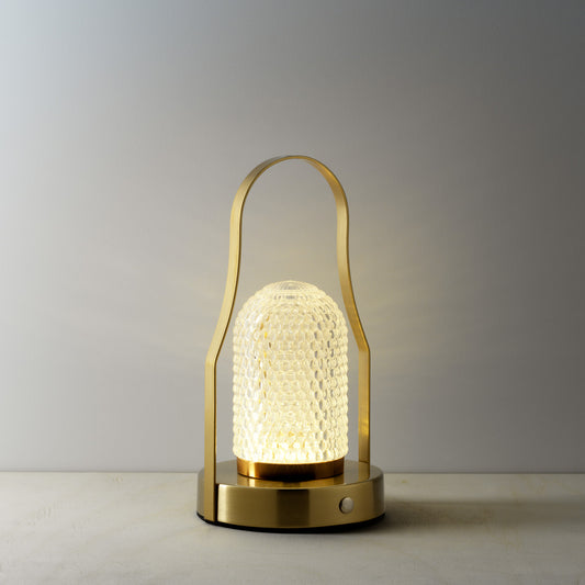 The Lampuccino LED Table Lamp, lit on grey surface