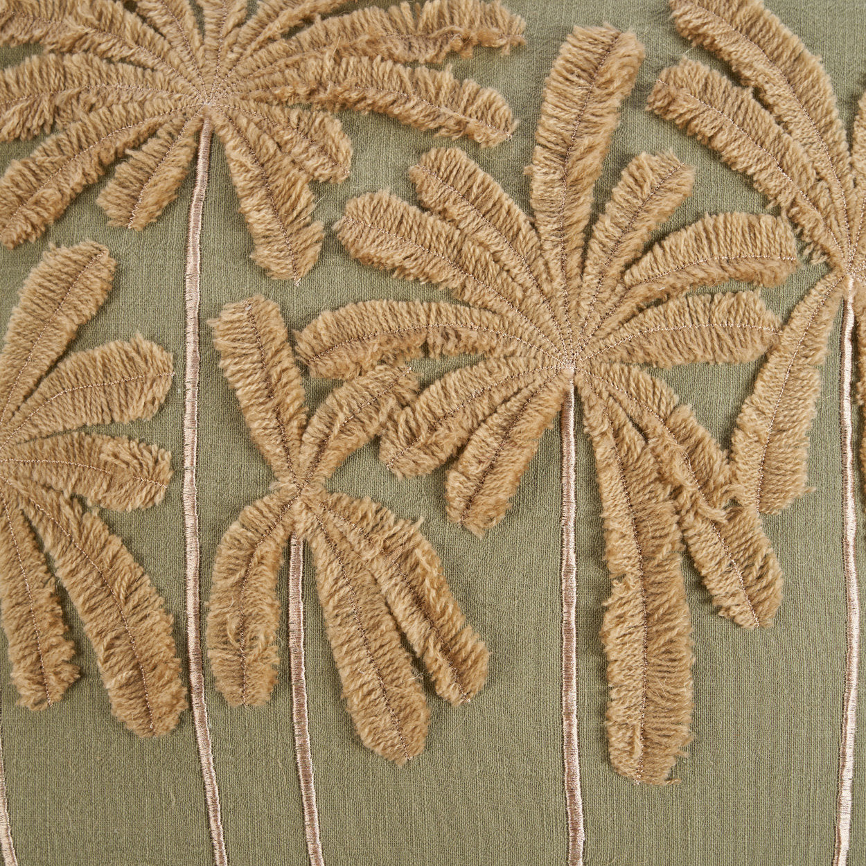 The Tropical Breeze Cushion Cover — lifestyle shot on teak chair with terracotta wall and palm leaf vase