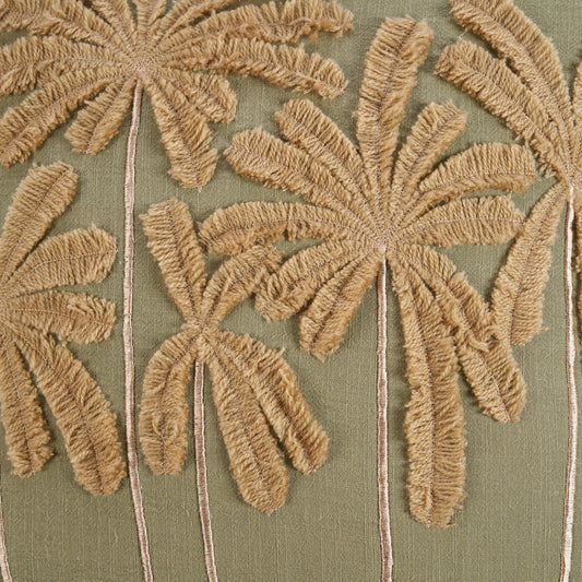 The Tropical Breeze Cushion Cover — lifestyle shot on teak chair with terracotta wall and palm leaf vase