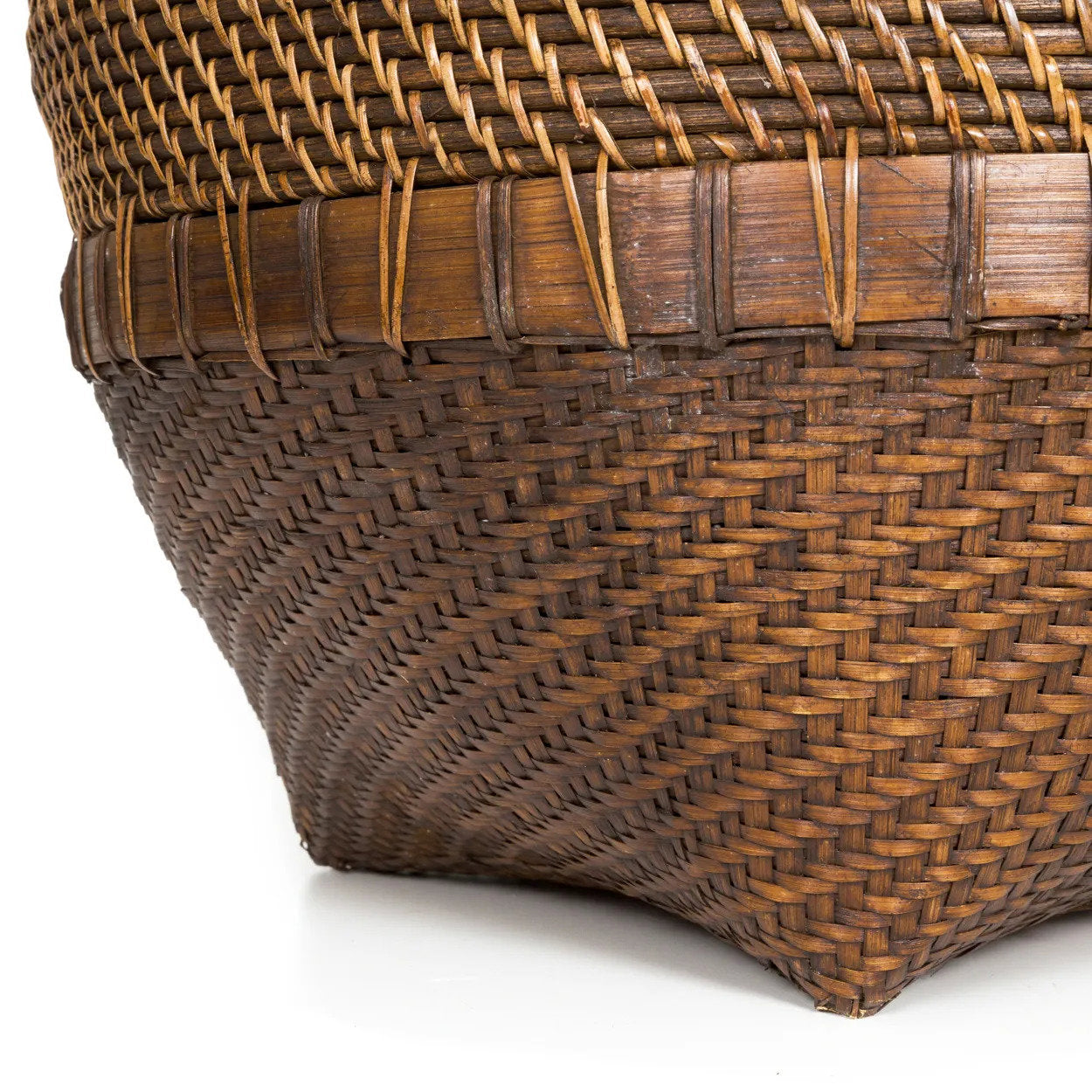 The Colonial Laundry Basket XL in a minimalist outdoor courtyard with bamboo plant