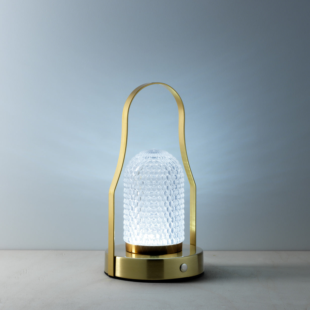 The Lampuccino LED Table Lamp, lit warm tone grey background