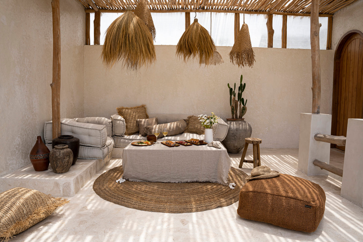 The Linen Tablecloth — Beige 150×150, lifestyle on low table with sushi and wine