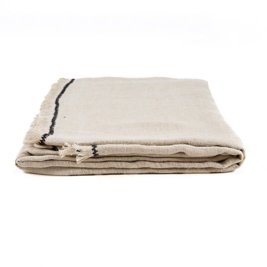 The Tuscany Tablecloth — Natural Black 150×300, draped on table corner detail