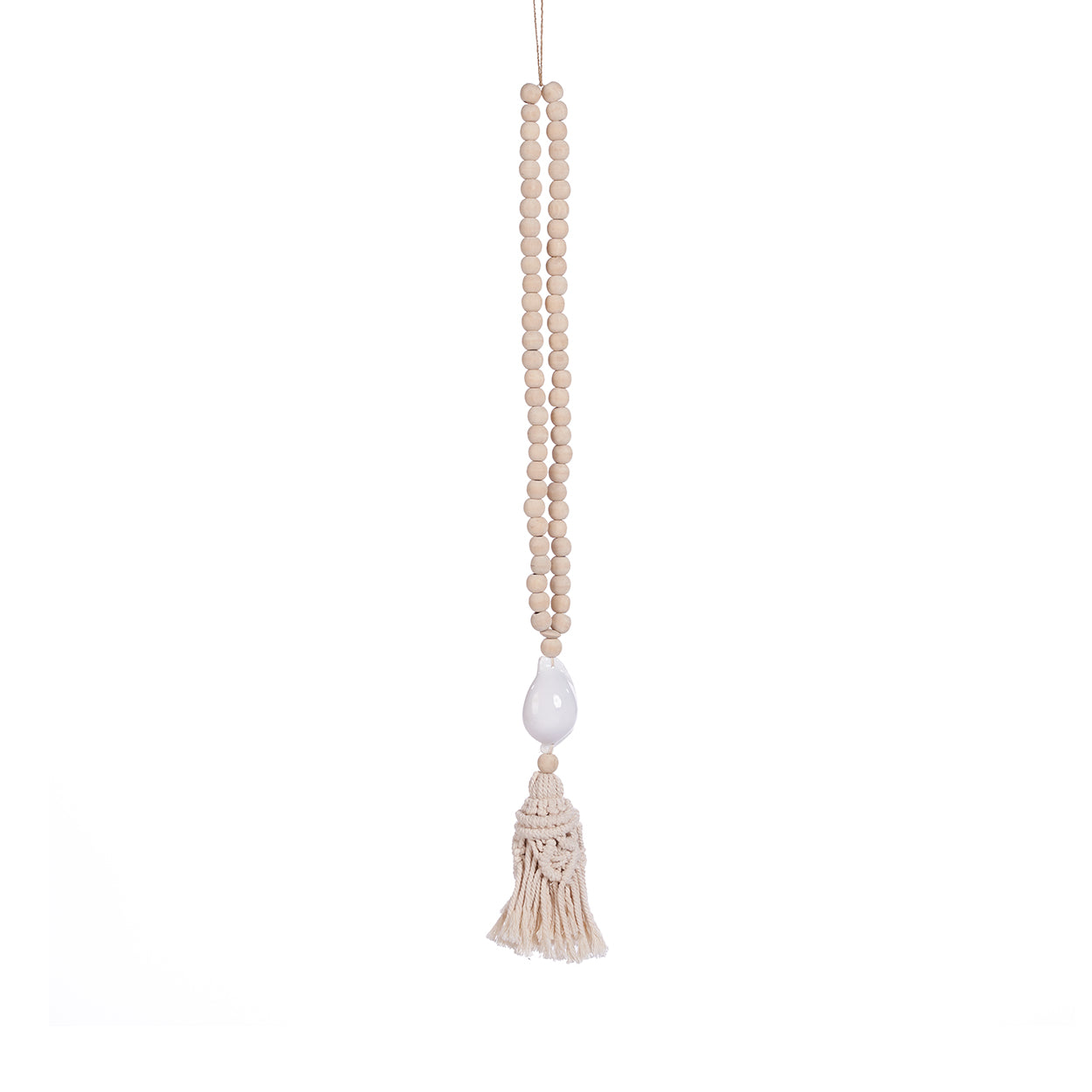 The Ocean Whisper Necklace — detail of white cowrie shell and macramé tassel, editorial lifestyle shot