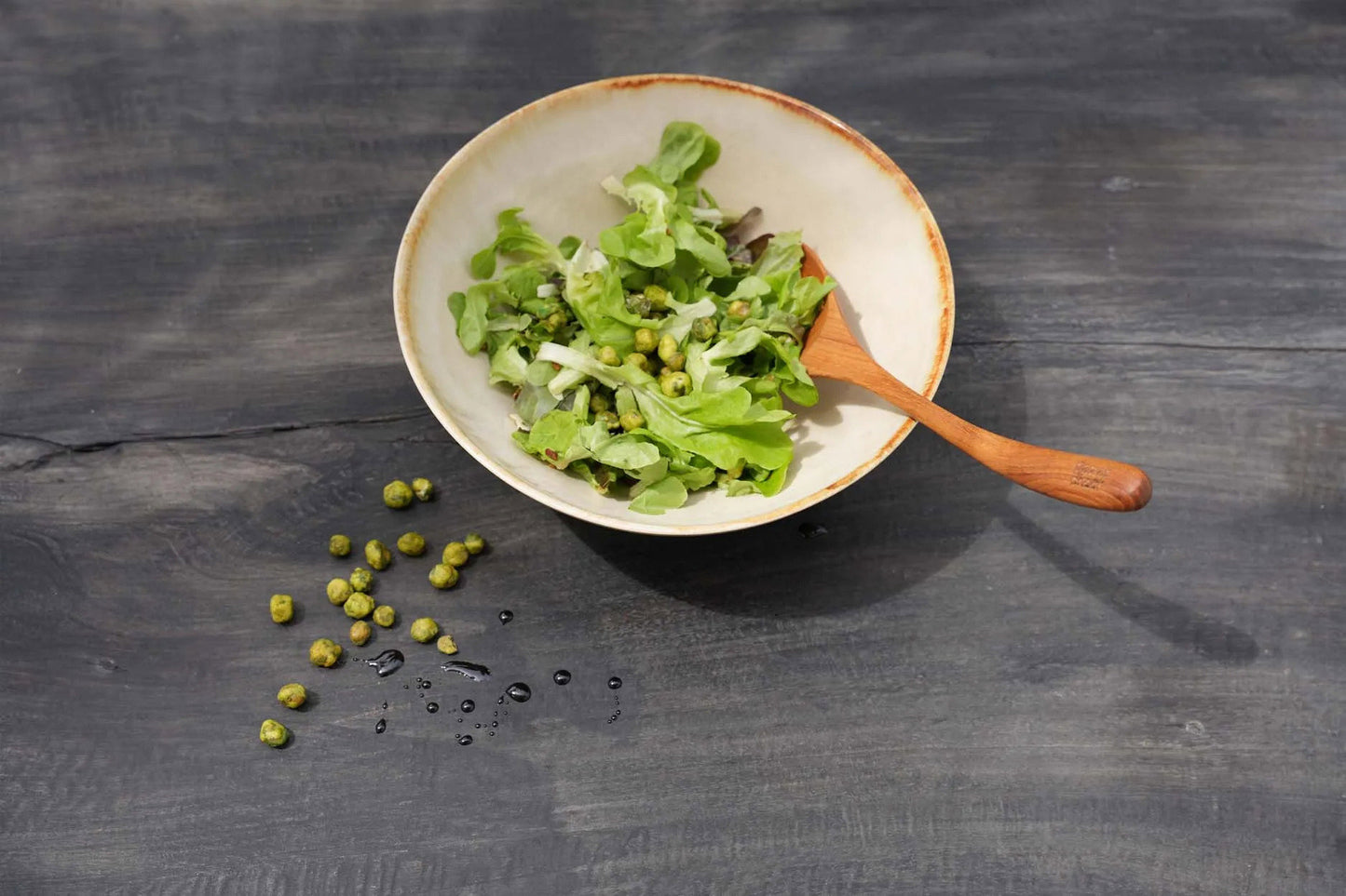 Close-up of the Cascais Small Bowl Plate rim showing the hand-applied burnt-umber glaze detail