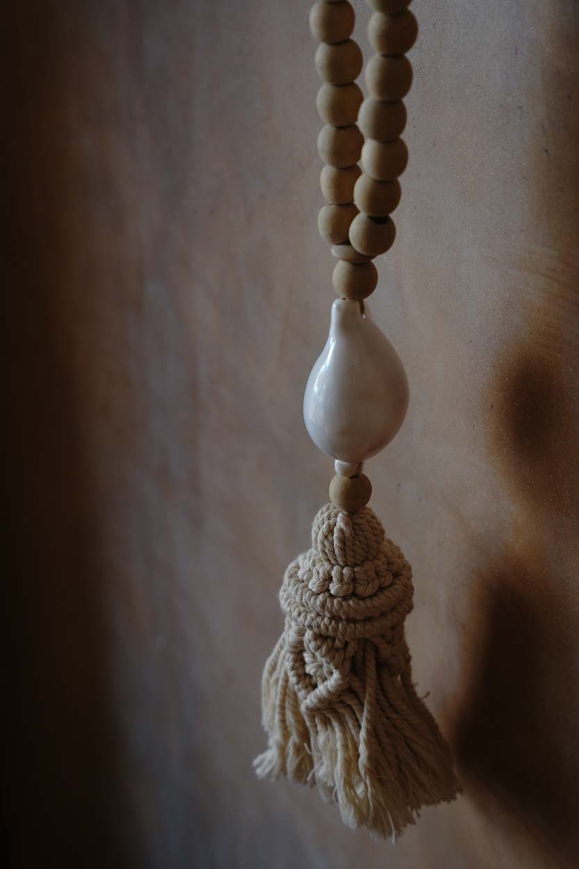 The Ocean Whisper Necklace — hanging on wall hook, full length lifestyle shot