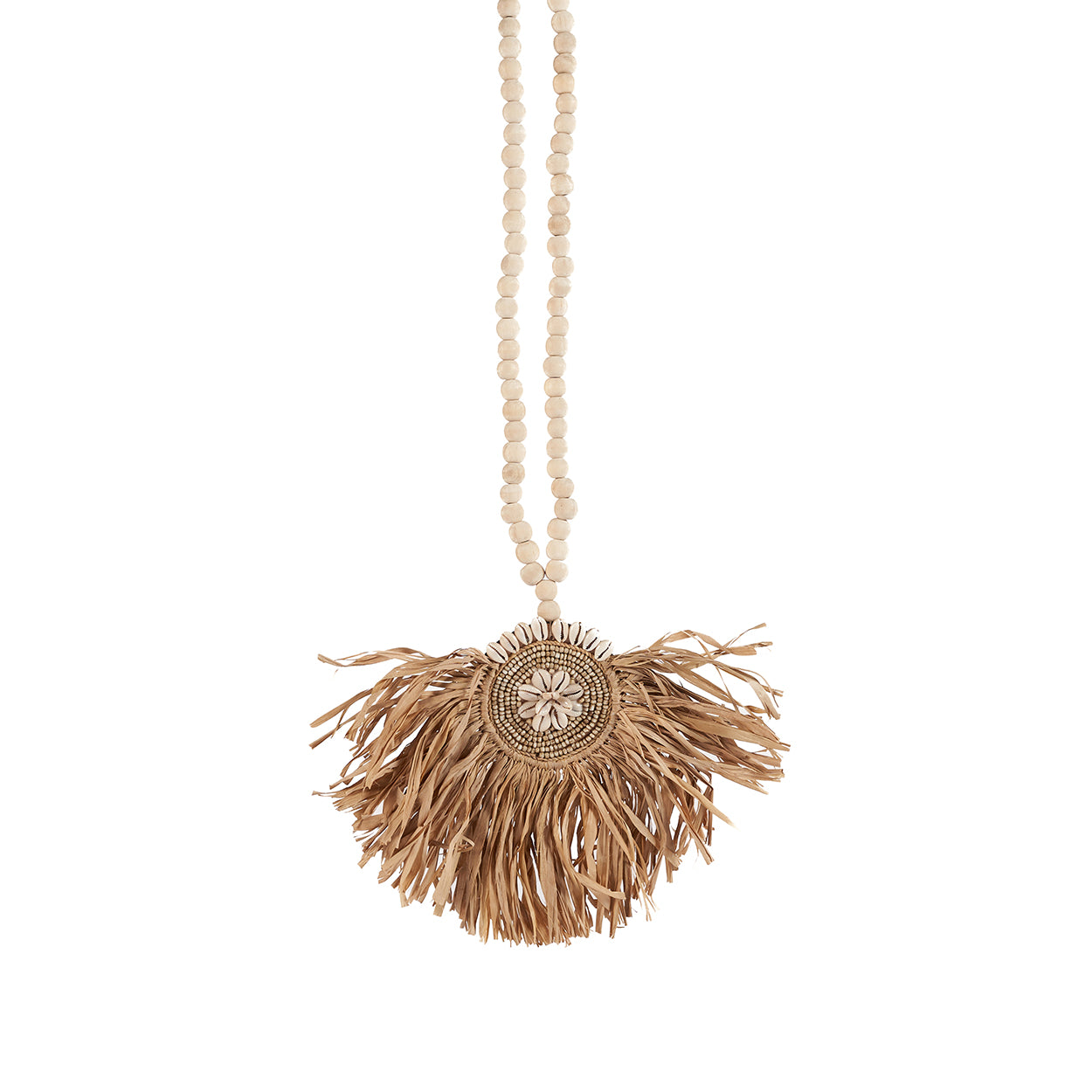 The Raffia Tajoe Tassel — Natural, lifestyle hanging on arched wall beside wooden door
