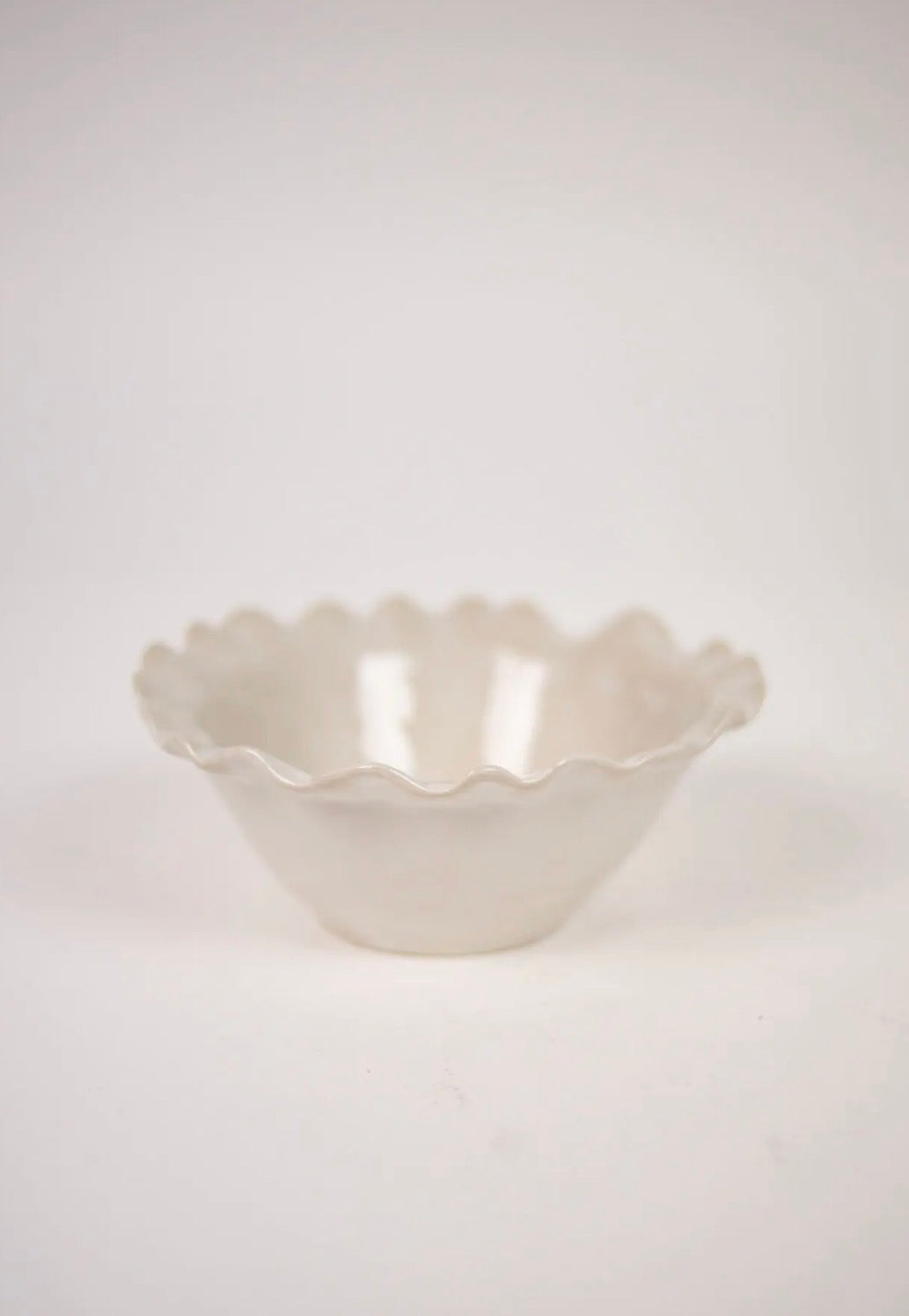 Valerie Bowl White — side view of white stoneware bowl with decorative wavy edge on light grey background