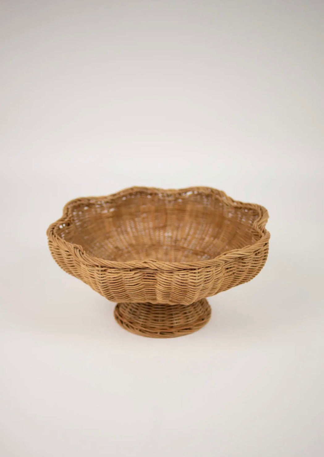 Magret Bowl on Foot — wide shallow hand-woven rattan bowl with scalloped rim on pedestal base, front view on white background