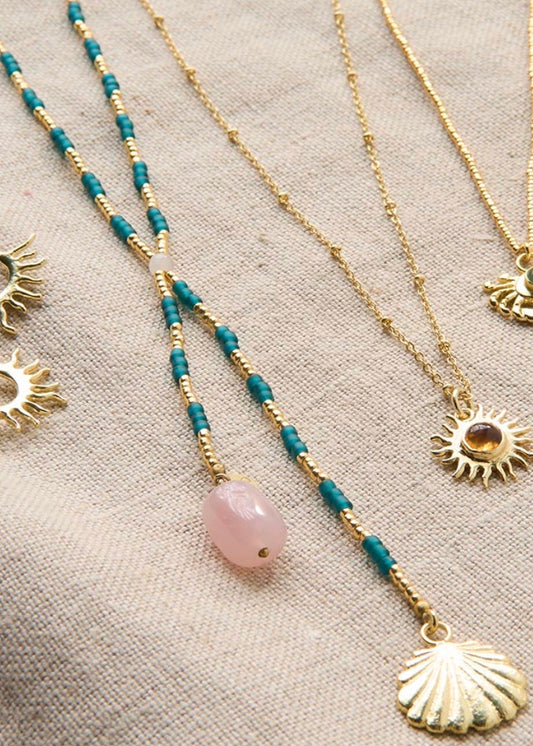 Entire Rose Quartz Necklace – Styled flat lay with beaded necklaces and shell pendant